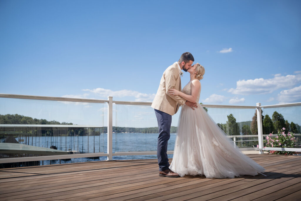 bride and groom kissing by water by Lake of the Ozarks wedding photographer The Bennetts