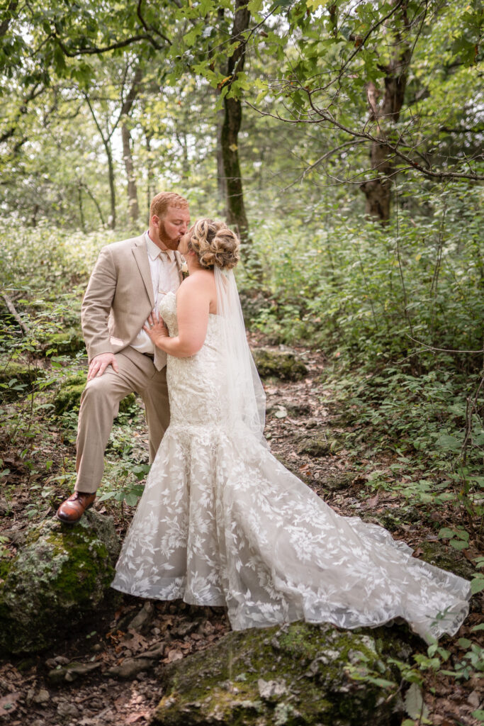 bride and groom kissing in the woods y Lake of the Ozarks wedding photographer The Bennetts