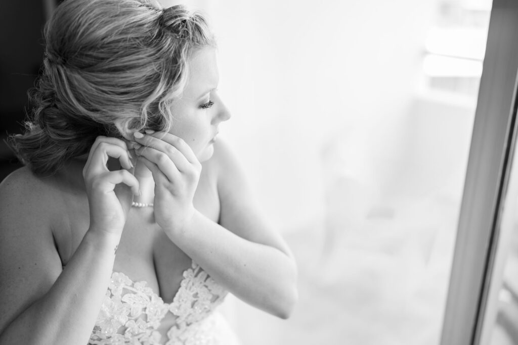 bride putting in earring by Lake of the Ozarks wedding photographer The Bennetts