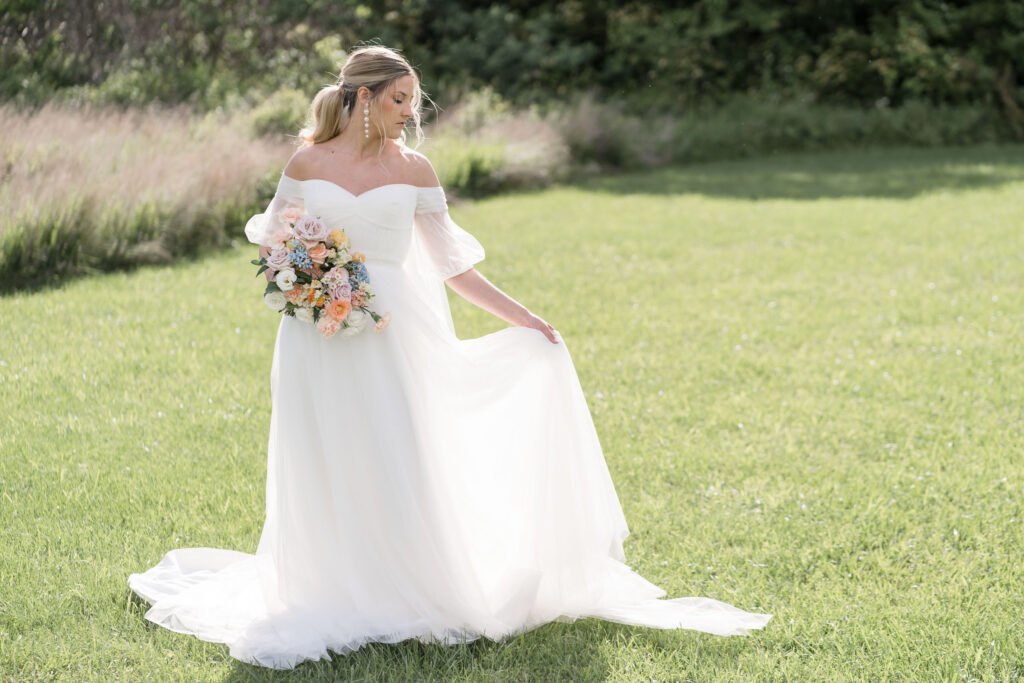 bride in a field by Lake of the Ozarks wedding photographer The Bennetts