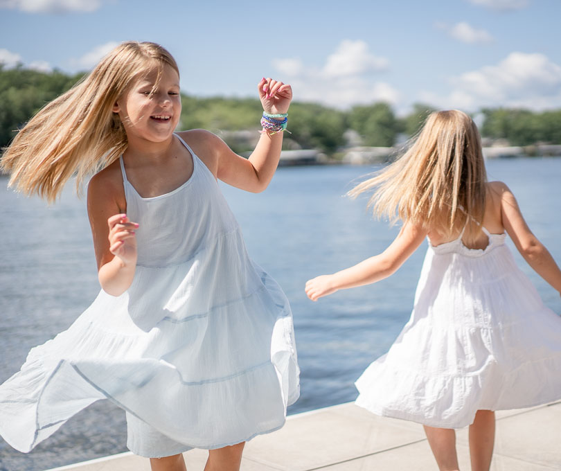 Girls twirling on a dock by Lake of the Ozarks photographer